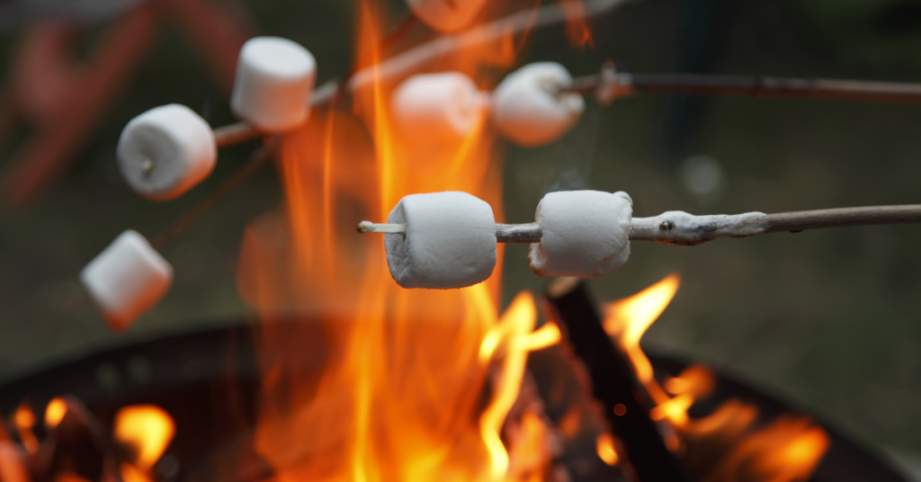 camping vs glamping toasting marshmallows on the fire you made